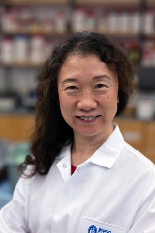 headshot of woman with long dark hair in white lab coat